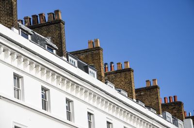 Low angle view of office building against blue sky