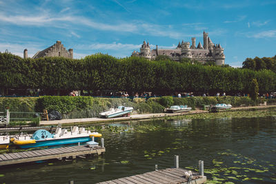 Scenic view of river by historic buildings against sky