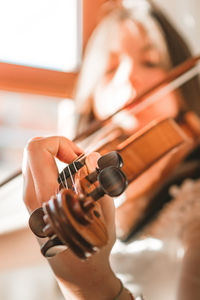 Close-up of woman playing violin at home