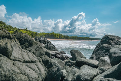 Panoramic view of rocks on beach against sky