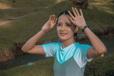 Portrait of young woman standing on rock