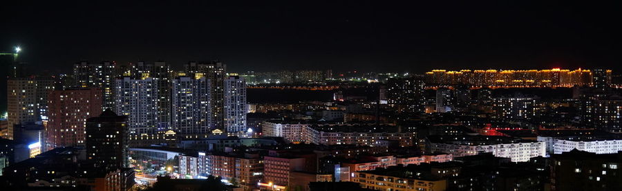 High angle view of illuminated buildings against sky at night