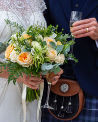 Midsection of woman holding bouquet of red roses