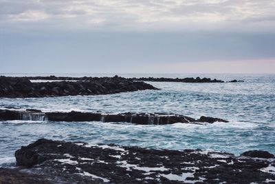 Scenic view of sea against cloudy sky