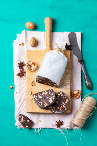 Traditional italian dessert - christmas chocolate salami with broken biscuits and walnuts on a table