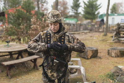 Boy wearing camouflage clothing while standing on field