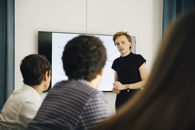 Confident businessman explaining strategy to colleagues in board room during meeting