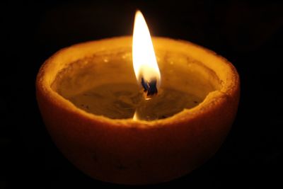 Close-up of illuminated candle in darkroom