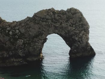 Rock formation in sea against sky