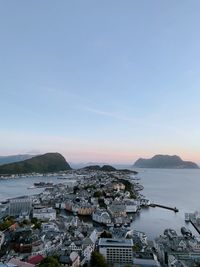 High angle view of city by sea against sky