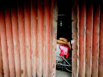 Woman sitting on chair against building