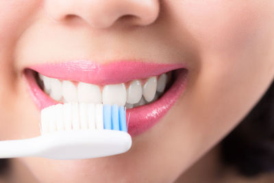 Cropped image of woman brushing teeth