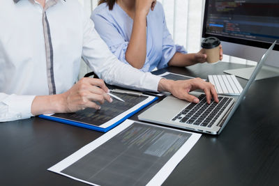 Midsection of woman using laptop on table