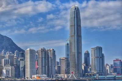 Modern buildings in city against cloudy sky