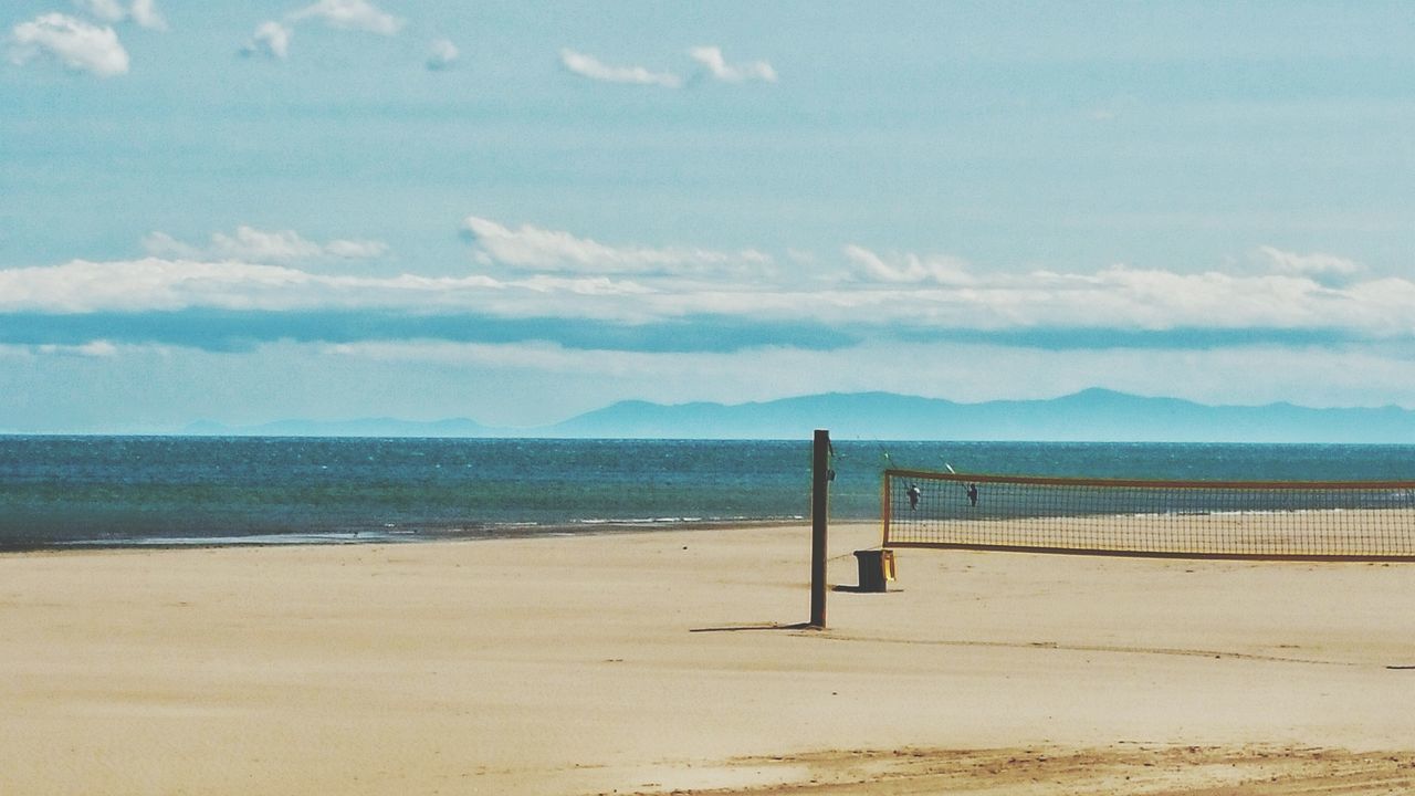 sea, beach, tranquil scene, sky, water, tranquility, sand, scenics, beauty in nature, shore, nature, mountain, horizon over water, pier, cloud - sky, idyllic, cloud, blue, railing, wood - material