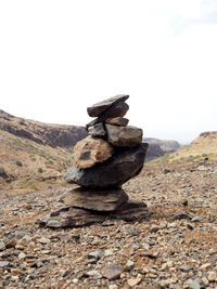 Stack of rocks on mountain against sky