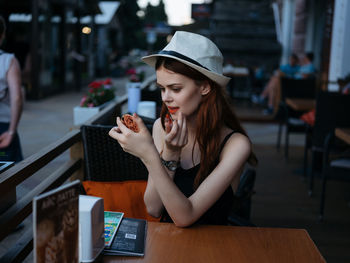 Woman sitting by table at restaurant