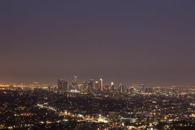 Illuminated cityscape against sky at night