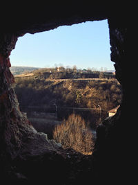 Scenic view of landscape against clear sky seen through window