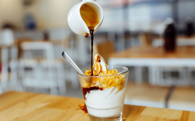 Close-up of pouring coffee in affogato on table