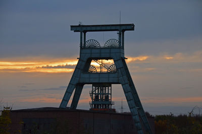 Low angle view of built structure against sunset sky