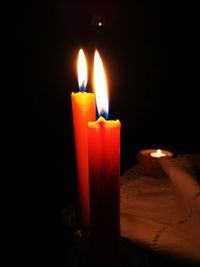 Close-up of lit candles in darkroom