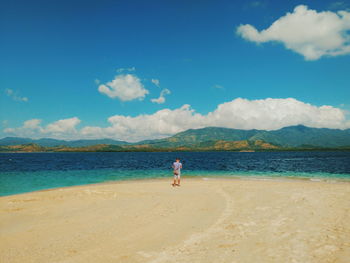 Woman on beach against blue sky