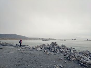 Woman standing on beach against clear sky