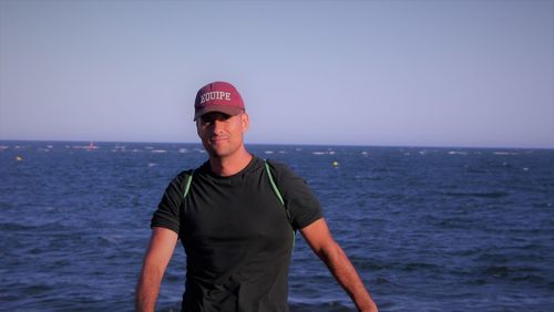 Portrait of man standing in sea against clear sky