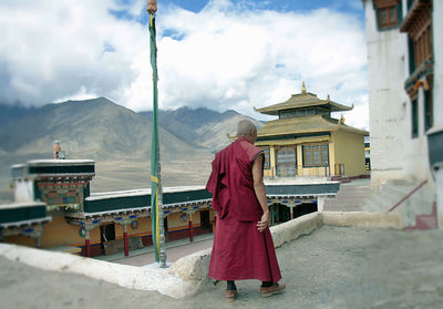 Panoramic view of traditional building by mountains against sky