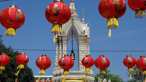 Low angle view of lanterns hanging against temple and sky