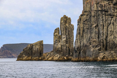 Rock formations by sea against sky