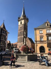 People outside historic building against sky