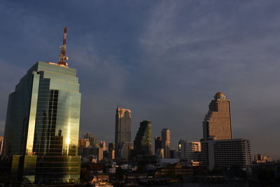 Modern buildings in city against cloudy sky