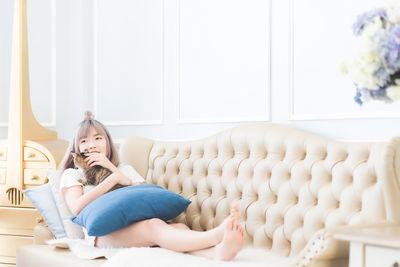 Portrait of woman sitting on sofa at home