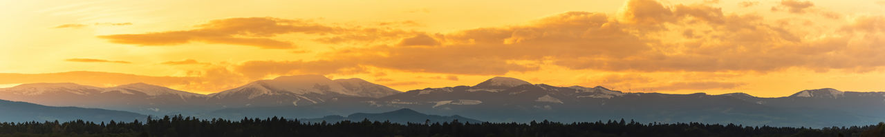 Styrian alps covered with snow in orange light of sunset. view at mountain chain of lavanttaler 