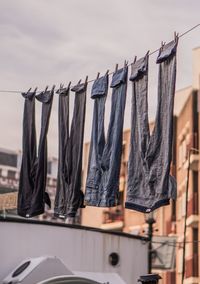 Close-up of clothes drying on clothesline against sky