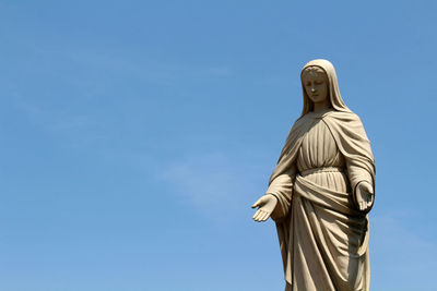 Low angle view of statue against blue sky