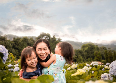 Portrait of a smiling young woman against plants