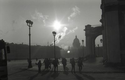 People on street in city against sky