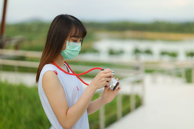 Midsection of woman photographing with smart phone