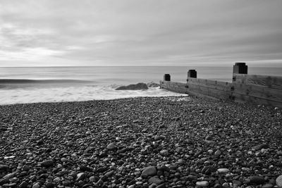 Stones on beach against sky