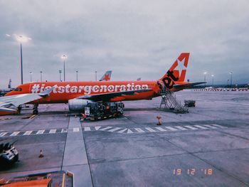 Airplane on airport runway against sky