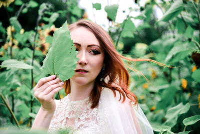 Portrait of woman against plants