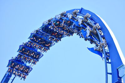 Low angle view of ferris wheel against blue sky