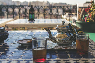 Close-up of drinks with teapot on table