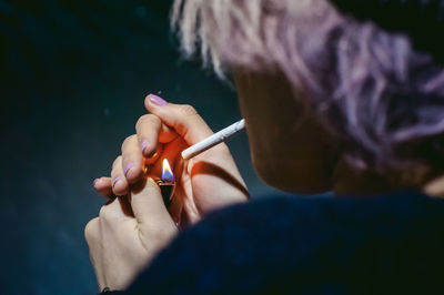 Close-up of young woman lighting cigarette