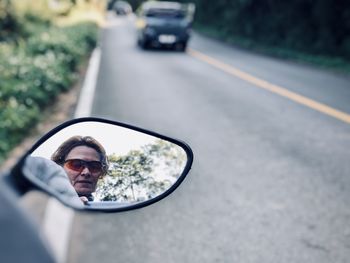Portrait of man wearing sunglasses on road