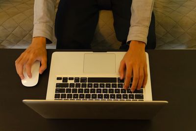 Midsection of man using laptop