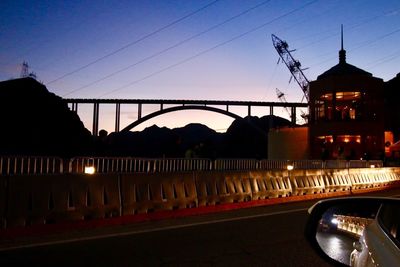 View of bridge over river at night